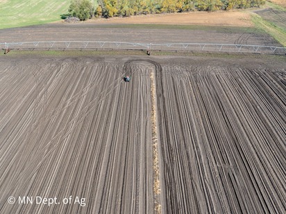 aerial view of potato field with person on ATV
