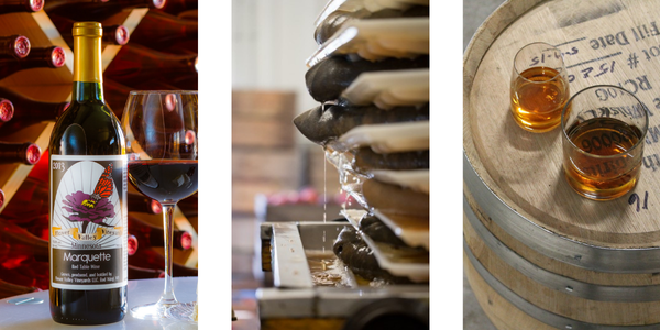 wine bottle and glass, apple press, whiskey glasses on a barrel
