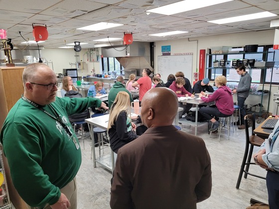 A teacher shows Commissioner Willie Jett a classroom where students are working