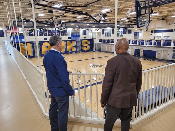 Commissioner Willie Jett and another man look over the Hermantown High School gymnasium. 