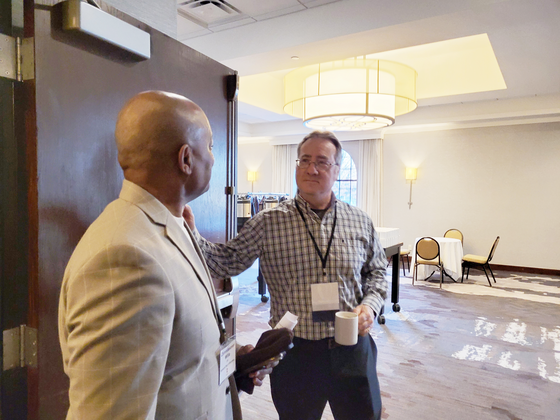 Commissioner Jett and another man speak together in a doorway