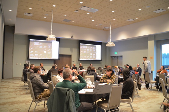 A man speaks into a microphone as a crowd listens