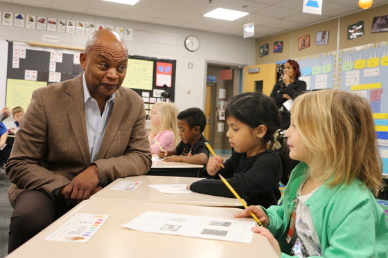 Commissioner Willie Jett speaks to students working at their desks