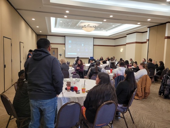 A man speaks at the back of the room as Commissioner Jett listens along with Jane Harstad and Melanie Franks