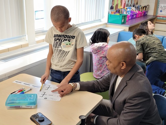 Commissioner Jett points to a paper as a student looks at the paper while working together at the students desk