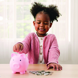 Child putting money in a piggy bank