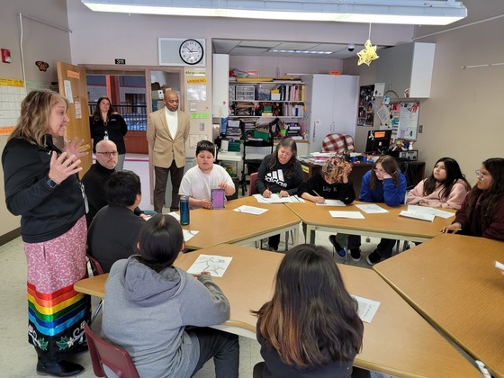 Commissioner Jett stands in a classroom observing students learning