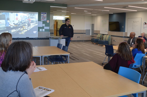 Anas Sumrin speaks in front of a group of people seated at tables