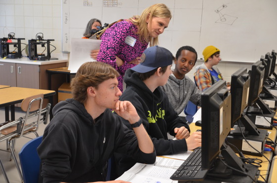 Jeanna Fortney stops to speak to students working at computers