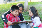 Mom reading with her kids in the park