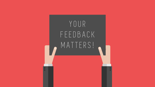 Hands holding sign that says "Feedback Matters"