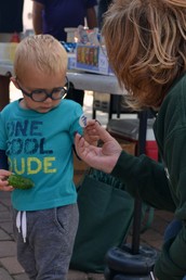 little kid getting token for farmers market