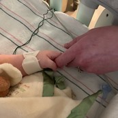 mother holding baby's hand in hospital