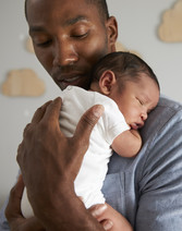 man holding infant in nursery