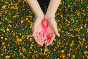 woman holding the breast cancer awarenss month ribbon 