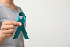 woman holding cervical cancer ribbon- teal 