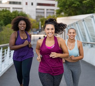African American women running outside on a bridge 