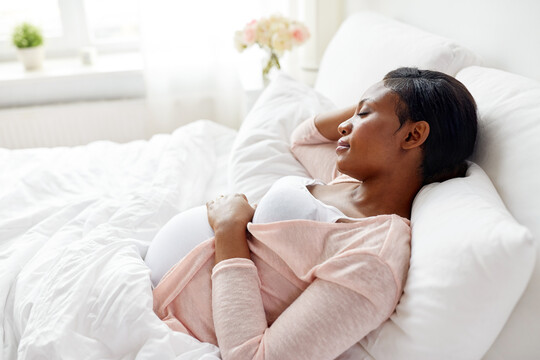 pregnant person lying in bed