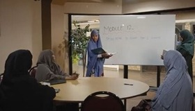 Four CHWs in a room with white board