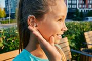 girl with hearing aid outdoors