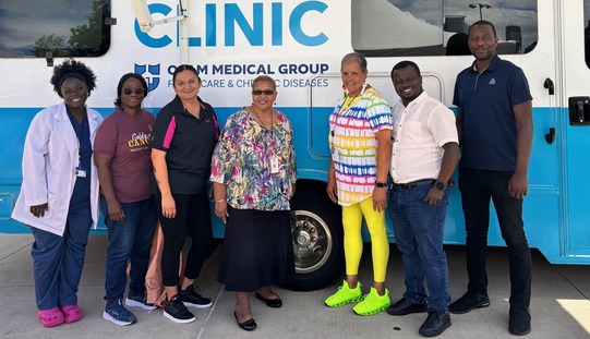 Odam Medical Clinic and Sage staff standing in front of Odam mobile clinic