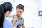 Child getting band-aid after a vaccination 