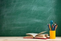 Chalkboard behind a book and container of pencils