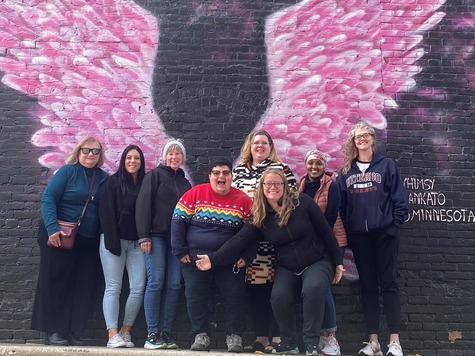 HEN team photo in Mankato, MN, in front of a mural