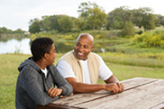 An adult male talking with a teenage male (photo from Adobe Stock)
