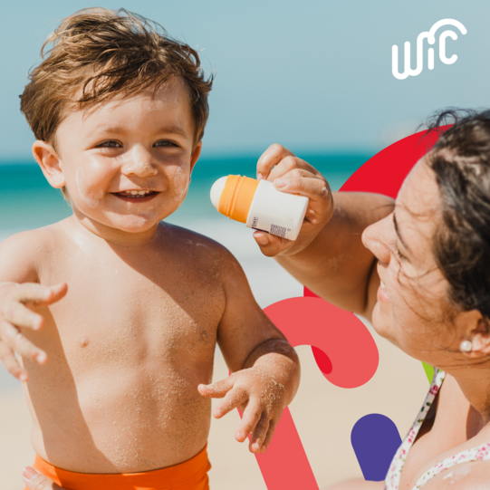 child outside getting sunscreen applied
