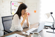 sick woman sitting at desk
