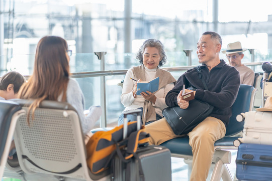 older couple sitting together at the airport gate 