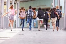 Students running at school with backpacks on