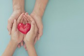 two sets of hands holding a heart