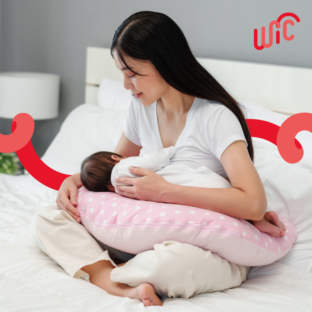 woman nursing infant on bed