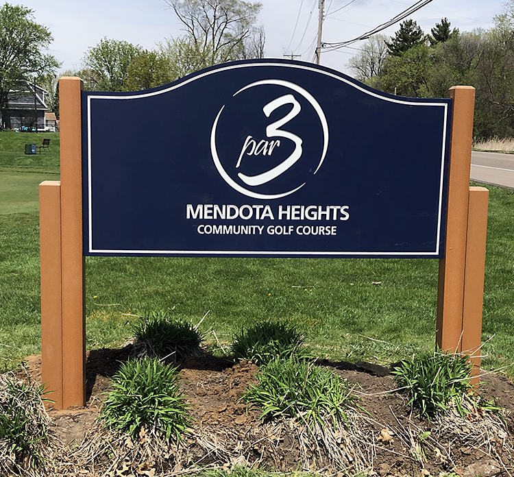 Navy blue entry sign with cedar-colored posts featuring Par 3 in white lettering within circular swoosh marks, Mendota Heights Community Golf Course.