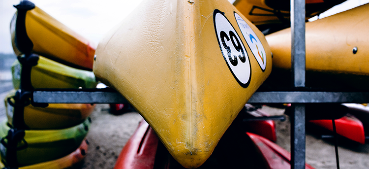Colorful canoes and kayaks stored on rack.