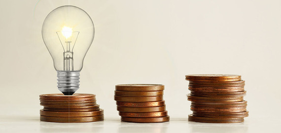 Light bulb sitting on one stack of three coins