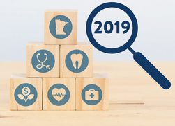 Insurance benefit icons and magnifying glass looking at the year 2019.