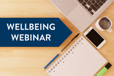 Desk with computer and text reading wellbeing webinar