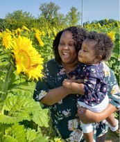 Erica and her daughter looking at sunflowers.