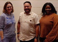 Three diverse people smiling at the Human Rights and Equal Economic Opportunity Commission swearing-in.