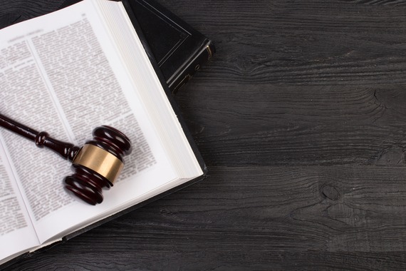 A law book laying open with a wooden gavel resting on top