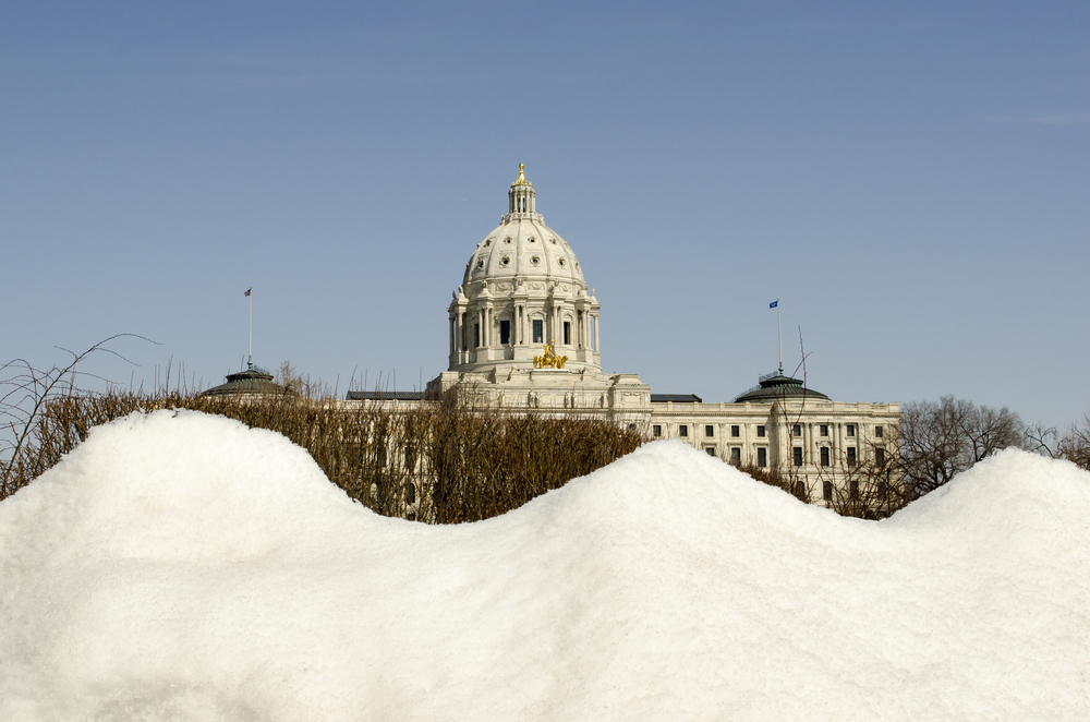 Minnesota State Capitol in winter with large snow pile in foreground