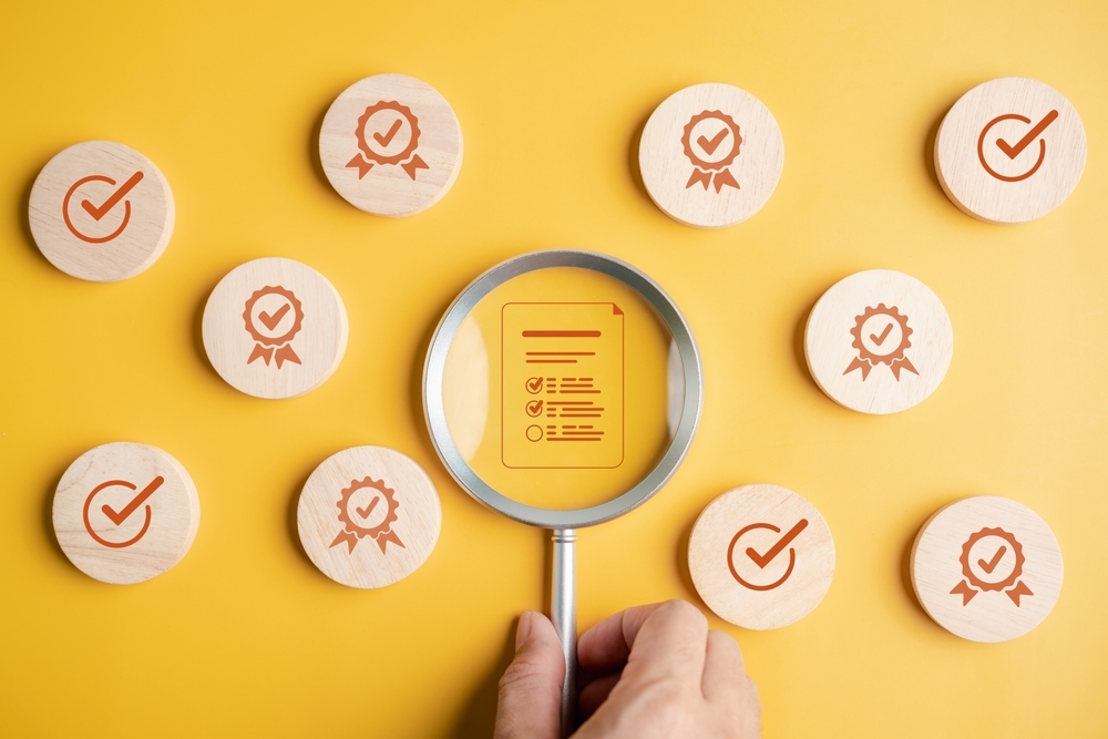 magnify glass with wooden blocks with check marks on yellow background