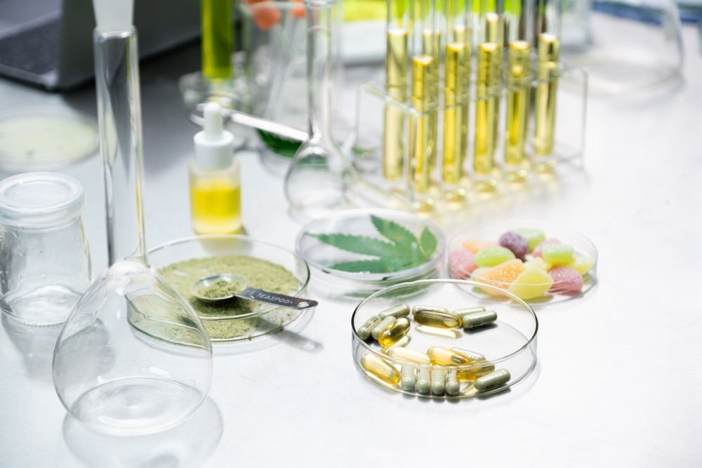 Cannabis products including Powders, Oil, Infused gummy, Gel pills, and Cannabis Capsules on scientist table in the laboratory