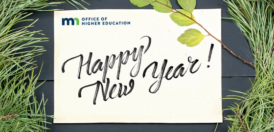 OHE New Year's Graphic with evergreen tree thistles on wooden background with note that reads "Happy New Year!"