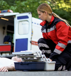 Image of female paramedic student treating a patient at an emergency scene
