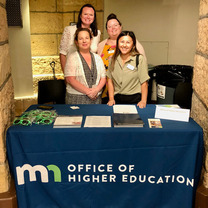 Four OHE employees at a booth.