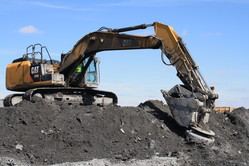 Excavator sifting through ash at Kalmar Landfill